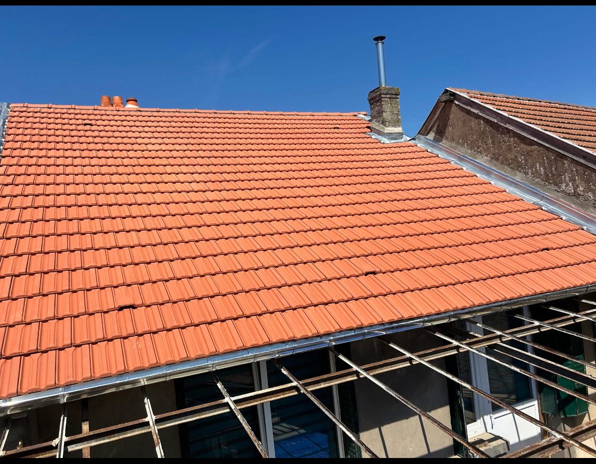 Toiture en tuiles neuves sous le ciel bleu