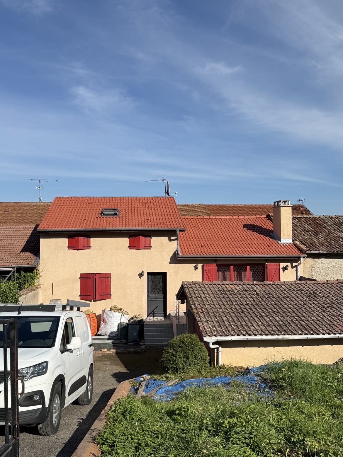 Maison aux volets rouges et son toit de tuiles